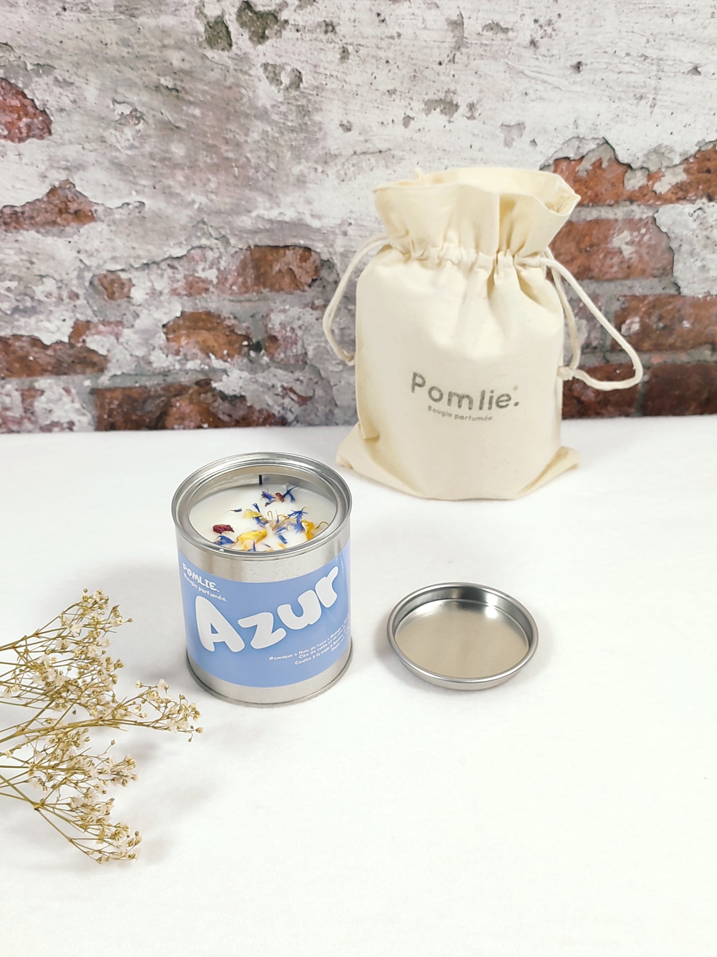 Bougie Pomlie Azur dans une boîte en métal bleue avec sac en coton.
