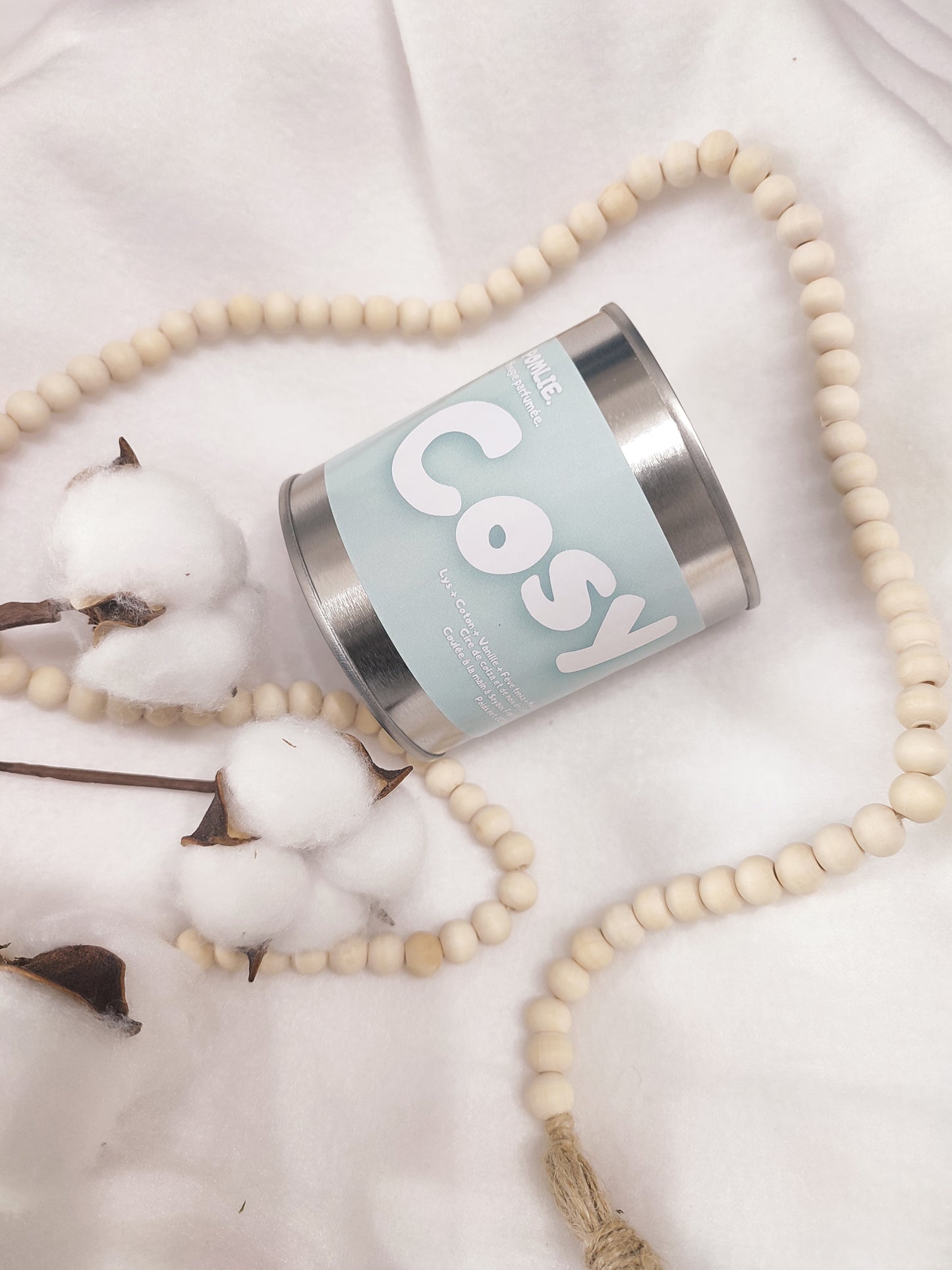 Bougie parfumée Cosy bleue avec bijoux et coton.