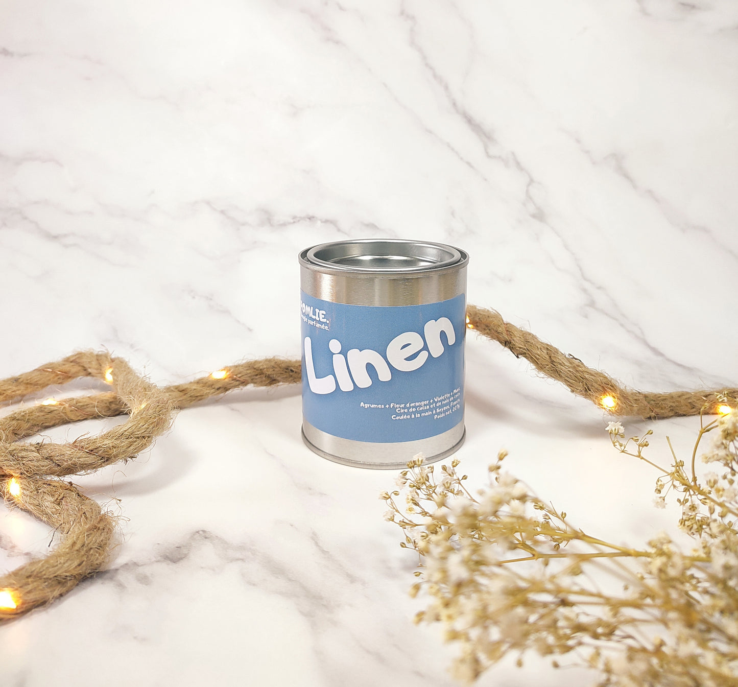 Bougie parfumée Linen fermée avec corde de décoration et fleurs séchées.