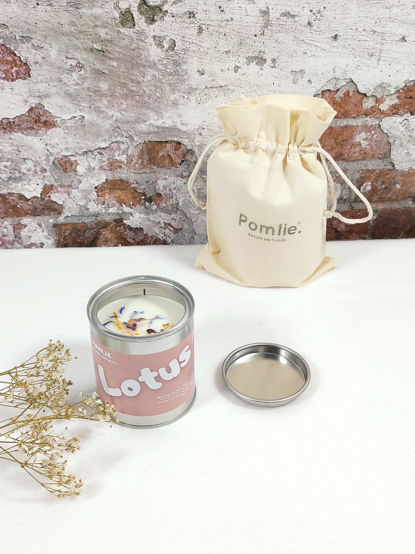 Bougie Pomlie Lotus dans une boîte en métal rose avec sac en coton.