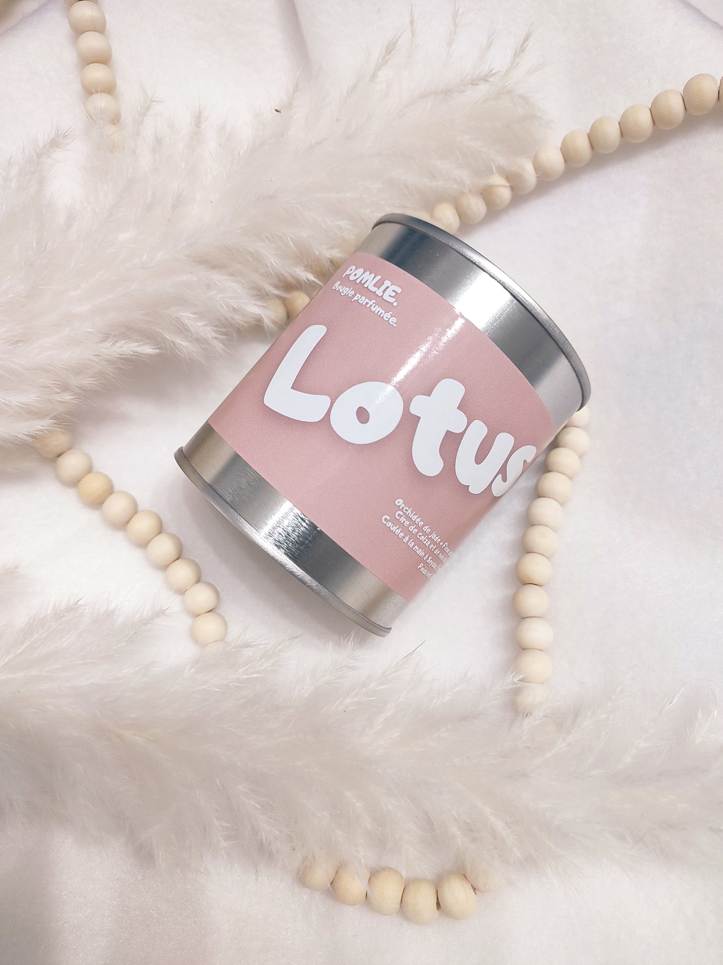 Bougie parfumée Lotus rose avec bijoux et plumes.