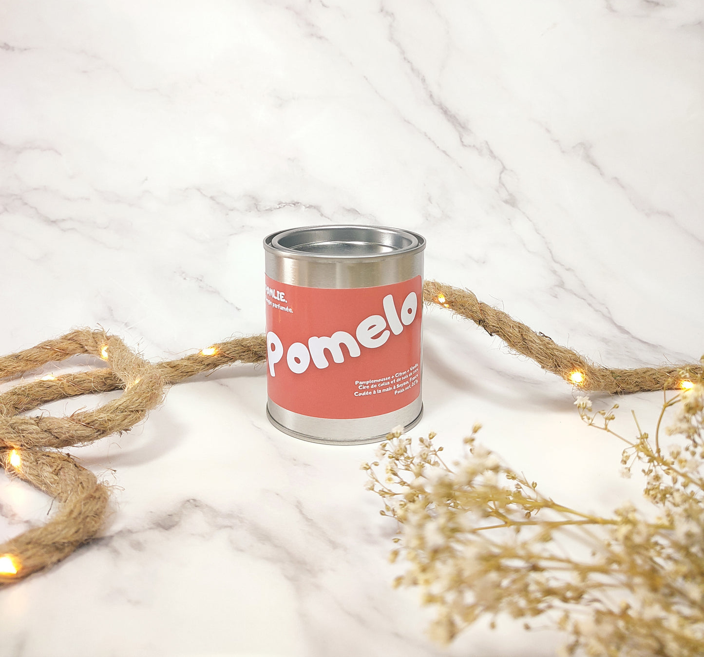 Bougie parfumée Pomelo fermée avec corde de décoration et fleurs séchées.