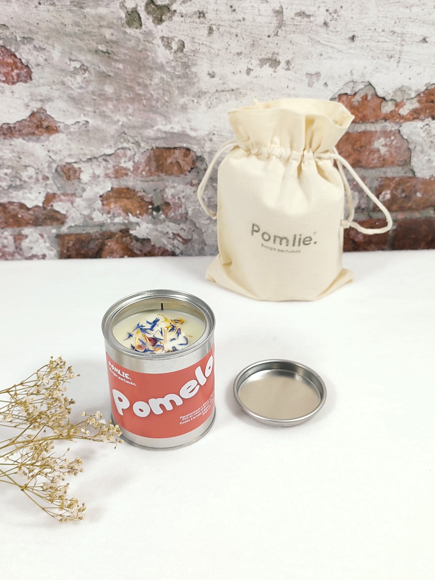Bougie Pomlie Pomelo en métal rouge avec sac en coton.