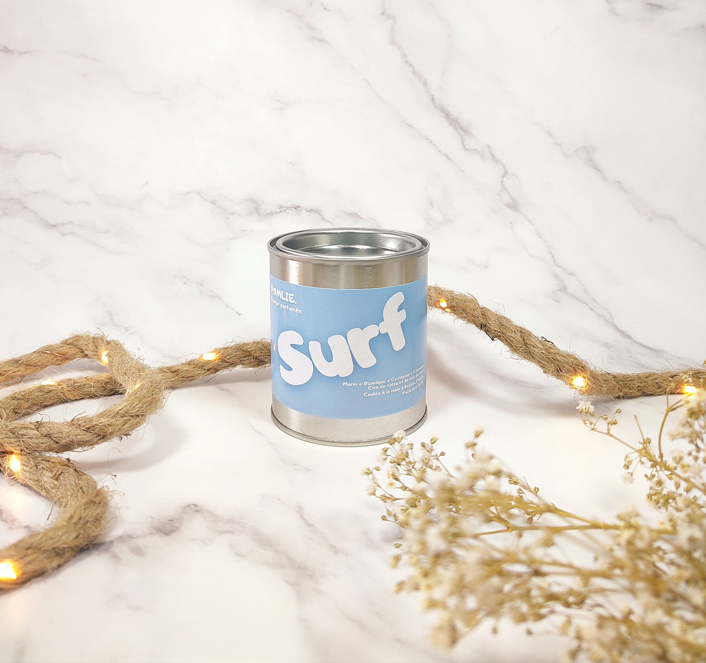 Bougie parfumée Surf fermée avec corde de décoration et fleurs séchées.
