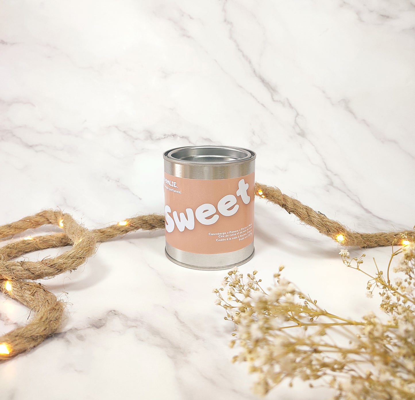 Bougie parfumée Sweet fermée avec corde de décoration et fleurs séchées.