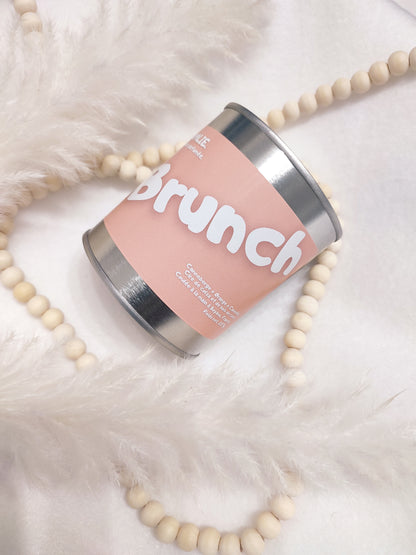 Bougie parfumée Brunch rose avec bijoux et plumes.