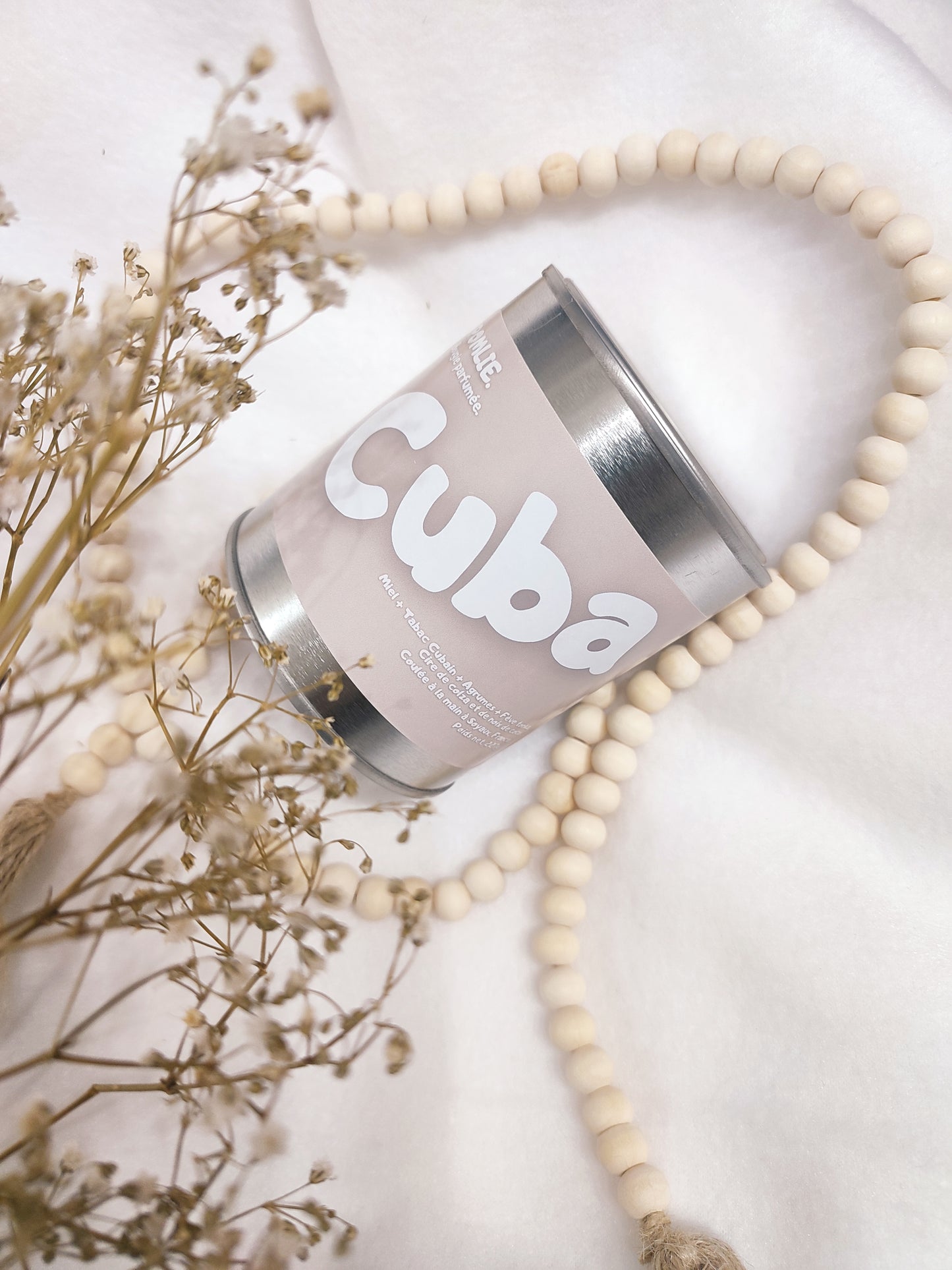 Bougie parfumée Cuba rose avec bijoux et fleurs séchées.