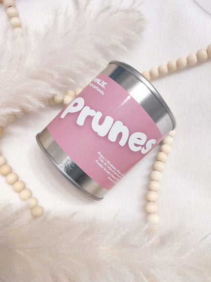 Bougie parfumée Prunes rose avec bijoux et plumes.